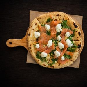 Pizza with smoked salmon, rocket and cottage cheese